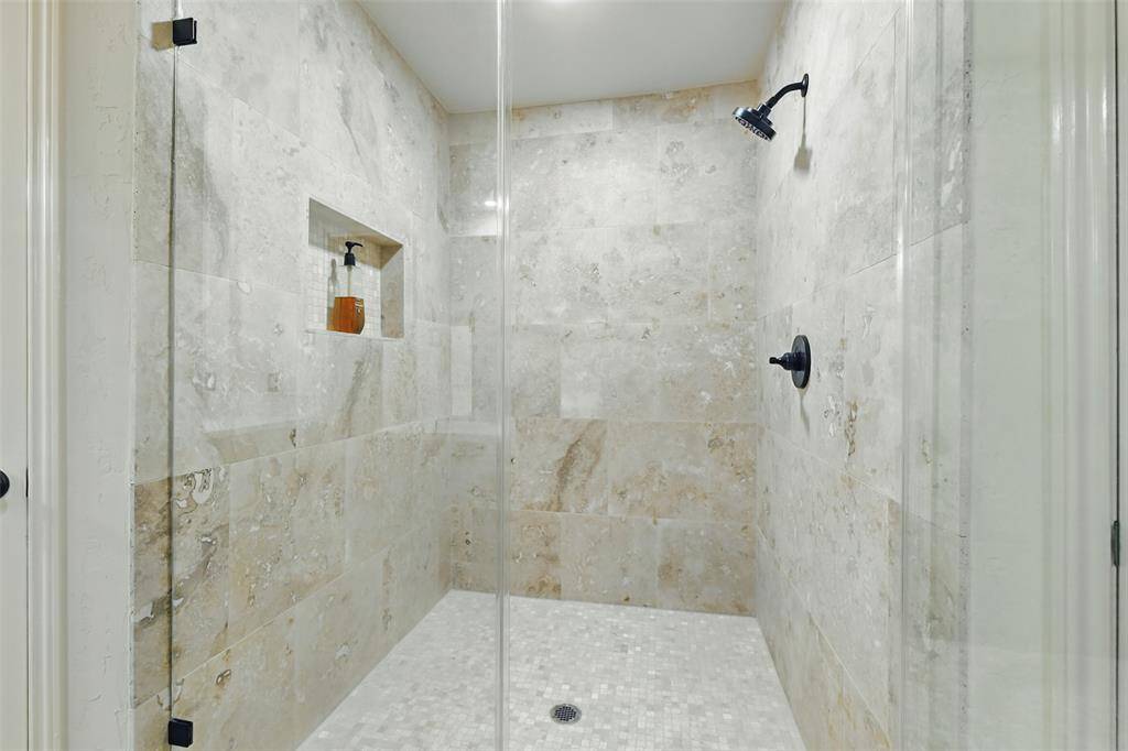 The oversized primary shower was recently remodeled in 2025 with tile surround and a seamless glass door.