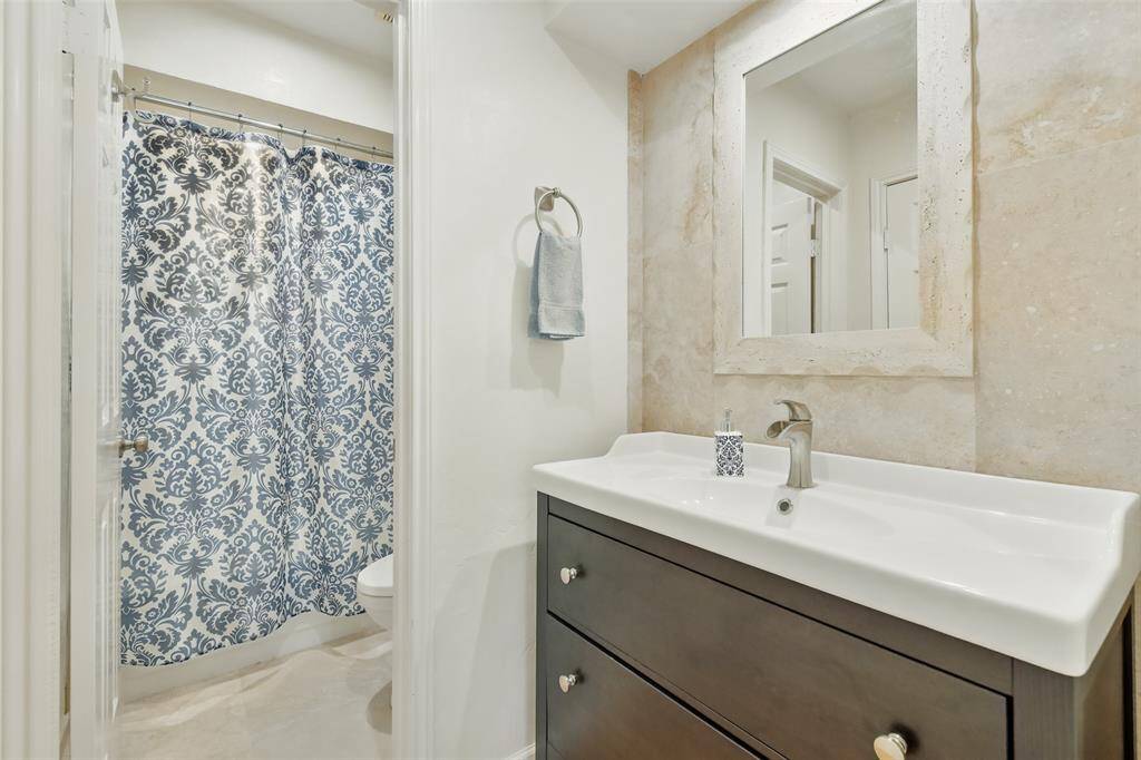 The third bedroom's ensuite bathroom includes an updated vanity, tile floors and a tub+shower duo.