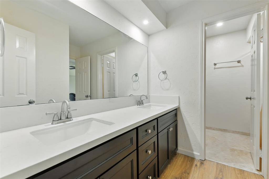 The upstairs full bathroom shared between the fourth and fifth bedroom features vinyl plank (2016) and tile floors, double sinks, an updated vanity and a tub+shower duo.