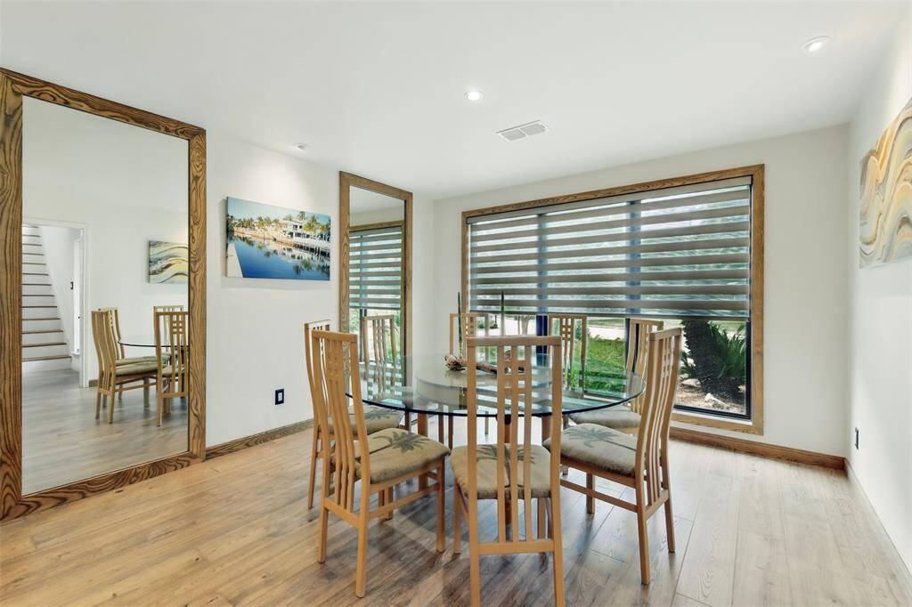 The light and bright dining room features luxury vinyl plank floors, recessed lighting and two full length mirrors.
