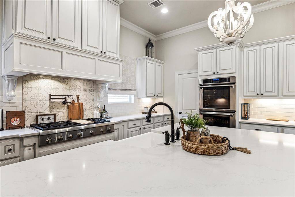 Every detail in this chef’s island kitchen was thoughtfully curated, from the Quartz countertops and custom cabinetry to the designer tile backsplash with mosaic inlay and under-cabinet lighting. A Thermador six-burner gas cooktop with pot filler, double ovens, built-in microwave and a deep farmhouse sink make cooking a joy, while elegant pendant lighting adds the perfect finishing touch.