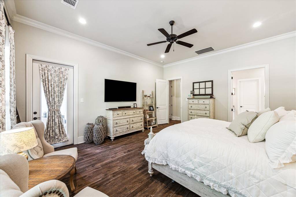 The serene primary retreat offers a peaceful escape, featuring rich wood-look tile flooring, soft neutral finishes, and an abundance of natural light. Enjoy the comfort of a custom walk-in closet and a luxurious spa-like ensuite with elegant finishes. A glass door provides direct access to the patio and pool area, while an adjoining bonus space offers the perfect spot for a private sitting area, home gym, or craft area.