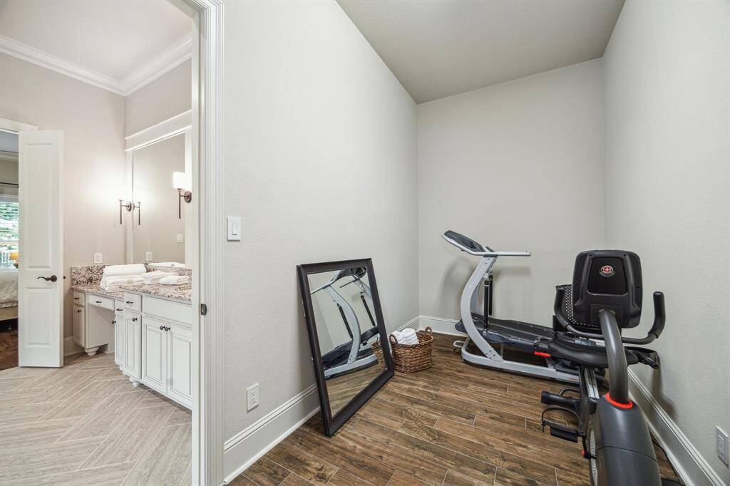 This extra room off of the primary bathroom features wood-look tile flooring, and makes for the perfect storage room, workout area, or craft room. The possibilities are endless!
