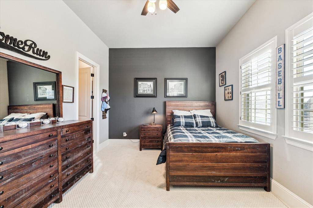 With two bedrooms on the first floor and three spacious bedrooms upstairs, this home provides plenty of room to comfortably host family and friends. This upstairs bedroom is a total home run offering cozy comfort, soft neutral tones, and plenty of space for rest, play, and personal touches. With a large closet, shuttered windows, and ensuite access to a full bath, it’s the perfect space for sluggers of all ages.