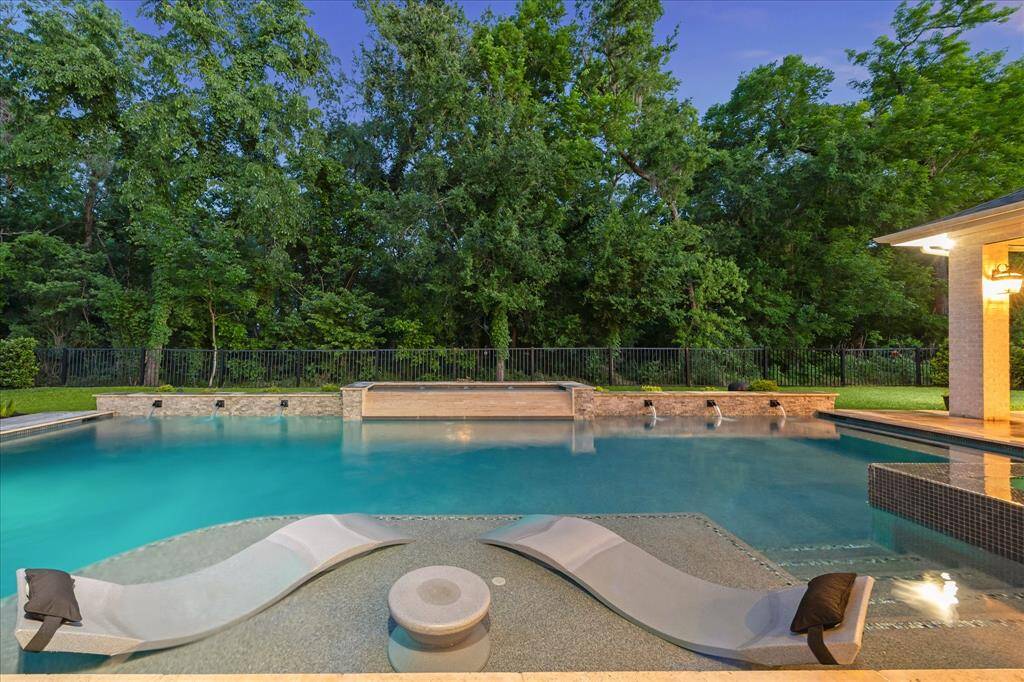 Whether you're basking on the tanning ledge or enjoying the soothing sound of cascading water features, this tranquil setting offers the ultimate escape. Equipped with both a chiller and a heater for year-round enjoyment, the pool is as functional as it is luxurious. With no back neighbors and a lush wooded backdrop, it’s a private haven where nature and comfort meet in perfect harmony.