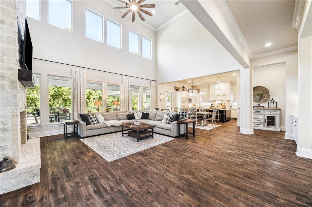 Imagine the sounds of laughter and chatter as you create lifelong memories in this beautiful home. The family room showcases wood-look tile flooring, an impressive gas-log fireplace, and picture-perfect views of the outdoor oasis and serene wooded backdrop. With its seamless flow into the casual dining area and kitchen, this inviting space is ideal for both everyday living and effortless entertaining.