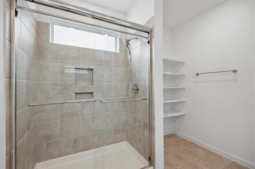 Oversized shower in Primary with custom shelves added next to the oversized shower.