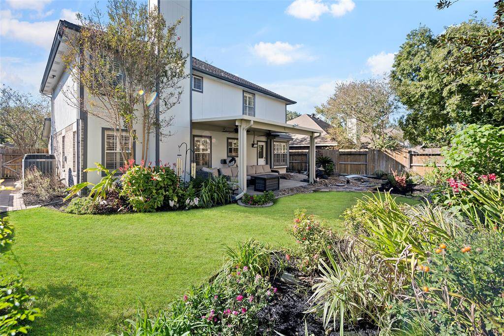 Enjoy the spacious patio perfect for outdoor gatherings, surrounded by lush greenery and vibrant flowers. Ideal for relaxation and entertaining.