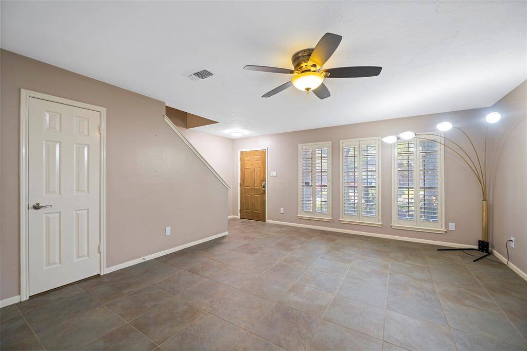 Bright and inviting living room, dining space or combine them featuring modern tile flooring and elegant plantation shutters.