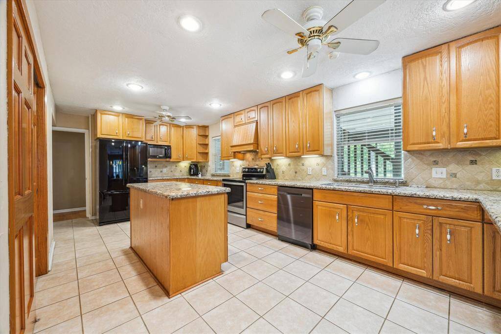 Enjoy seamless entertaining with a view from the formal dining room into the modern kitchen, featuring included appliances: refrigerator, microwave, range, and dishwasher.