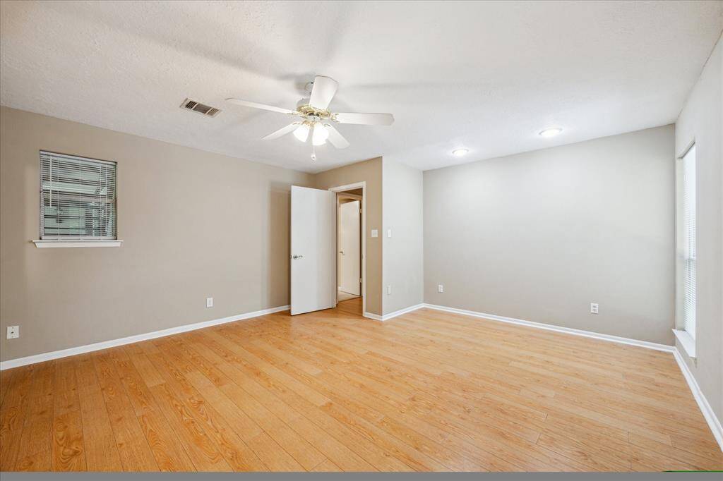 Spacious primary bedroom with natural light, and a modern ceiling fan for year-round comfort.
