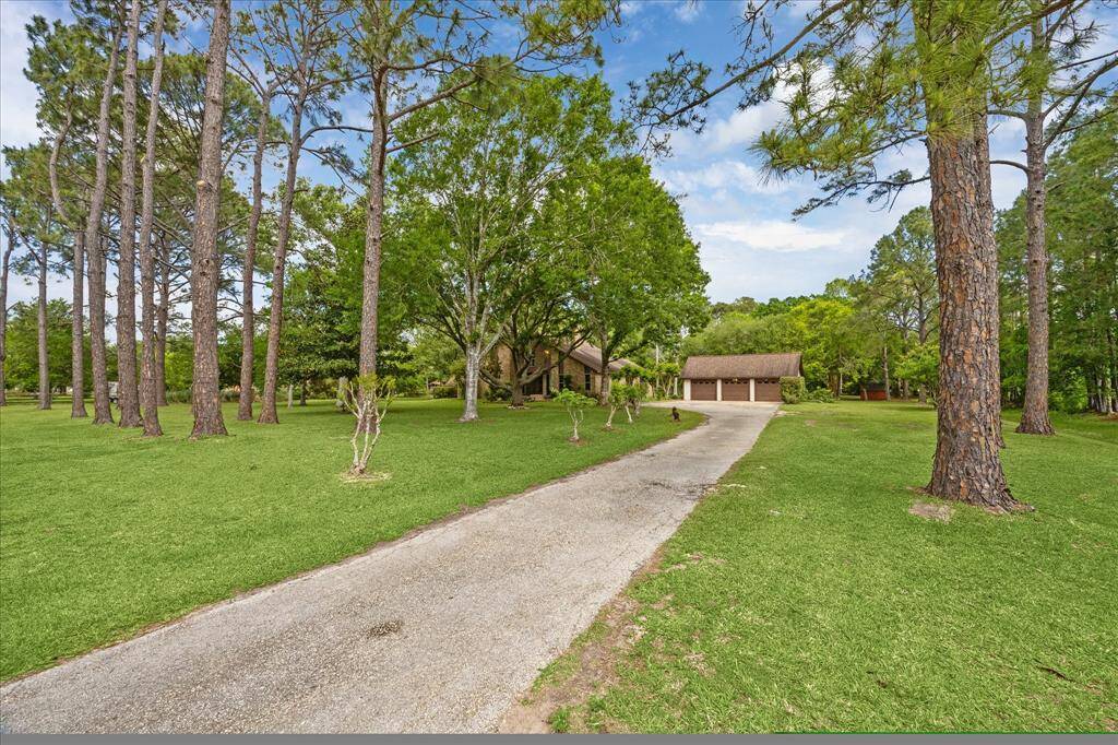 Nestled on two acres, this stunning home welcomes you with its expansive driveway and serene natural surroundings.