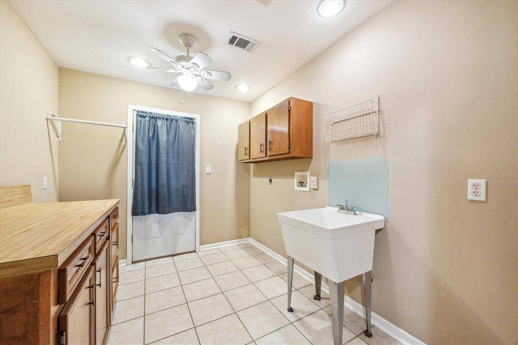 This utility room is perfectly positioned between the primary and secondary bedrooms, offering seamless access to an outdoor deck.
