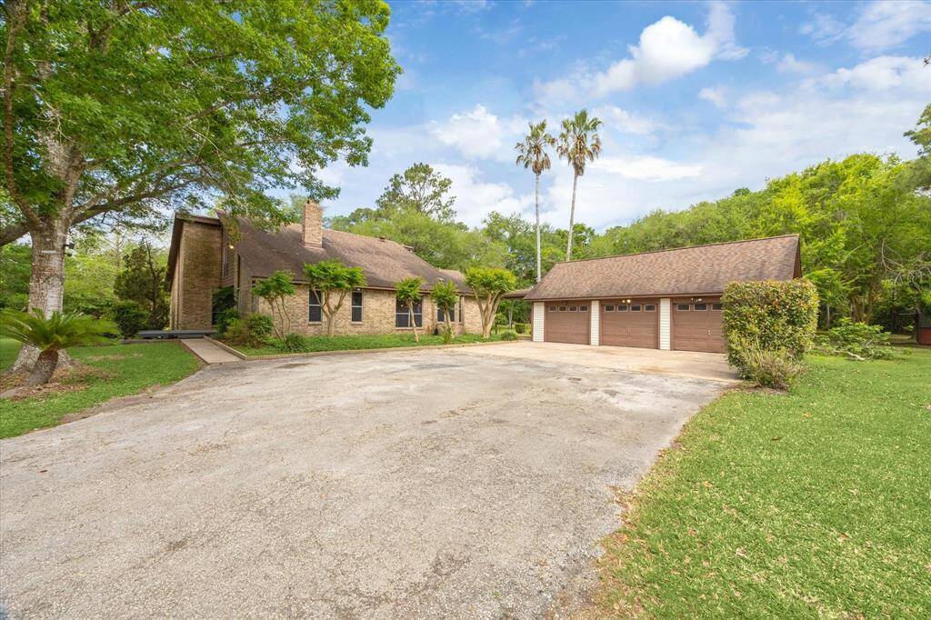 This home features a spacious driveway leading to both front and rear entrances, along with a three-car garage and an attached workshop.