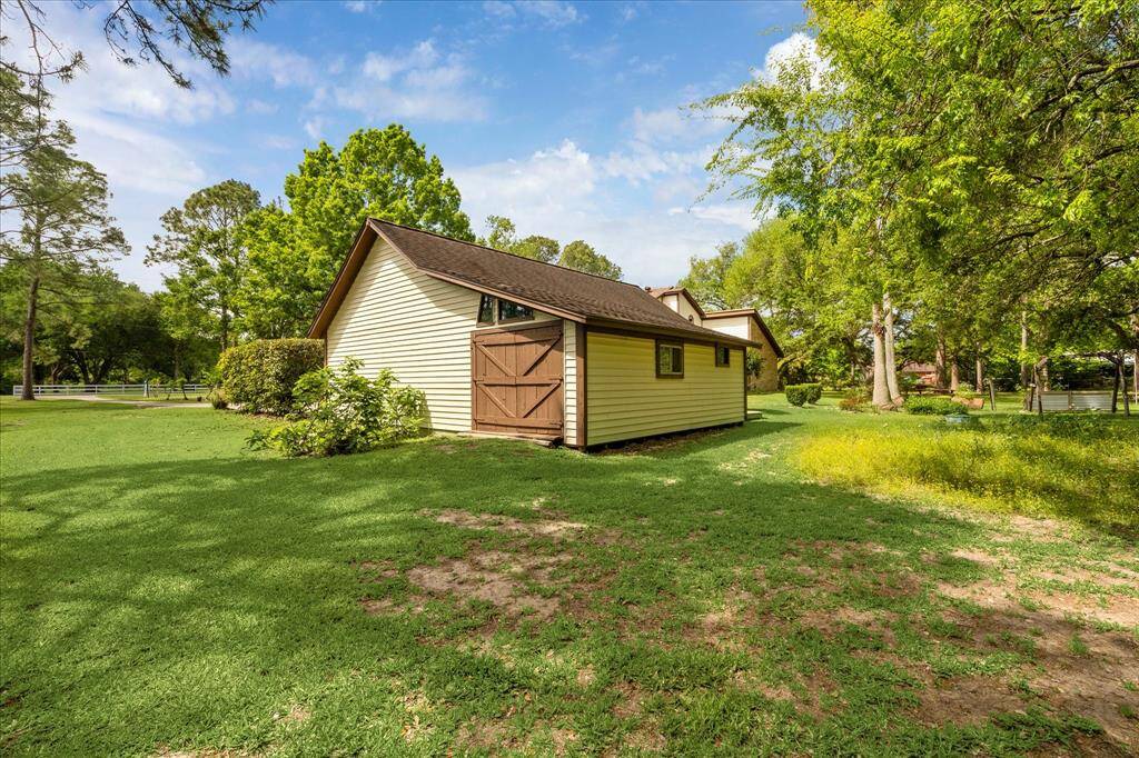 Spacious workshop with double doors, seamlessly connected to a three-car garage.