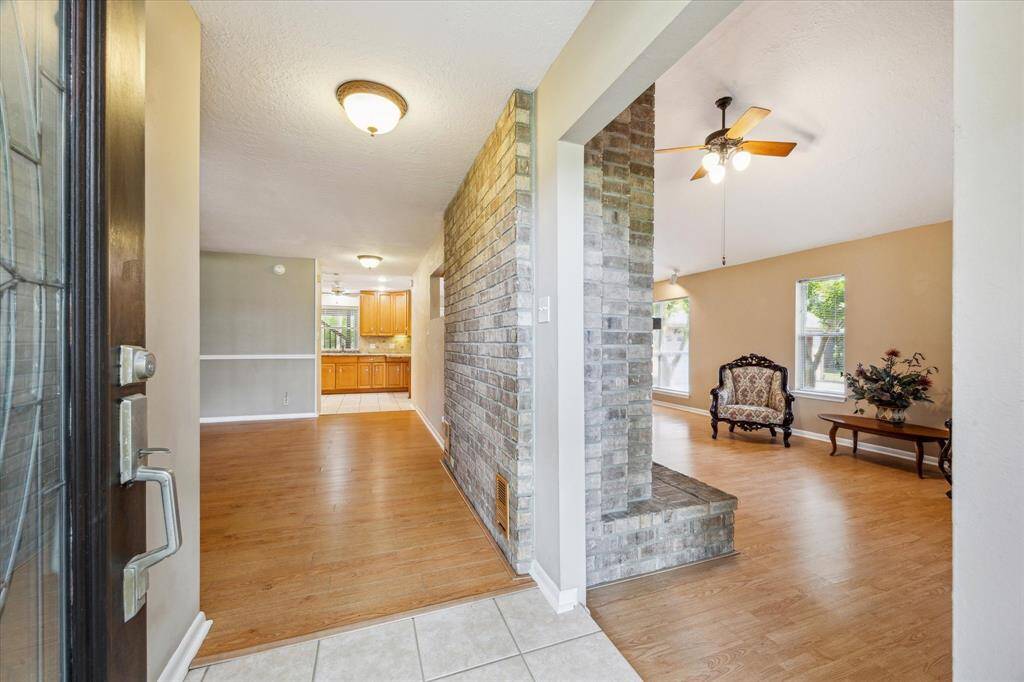 Step into a welcoming space featuring an open floor plan with warm wood floors and abundant natural light, seamlessly connecting the living and dining areas.