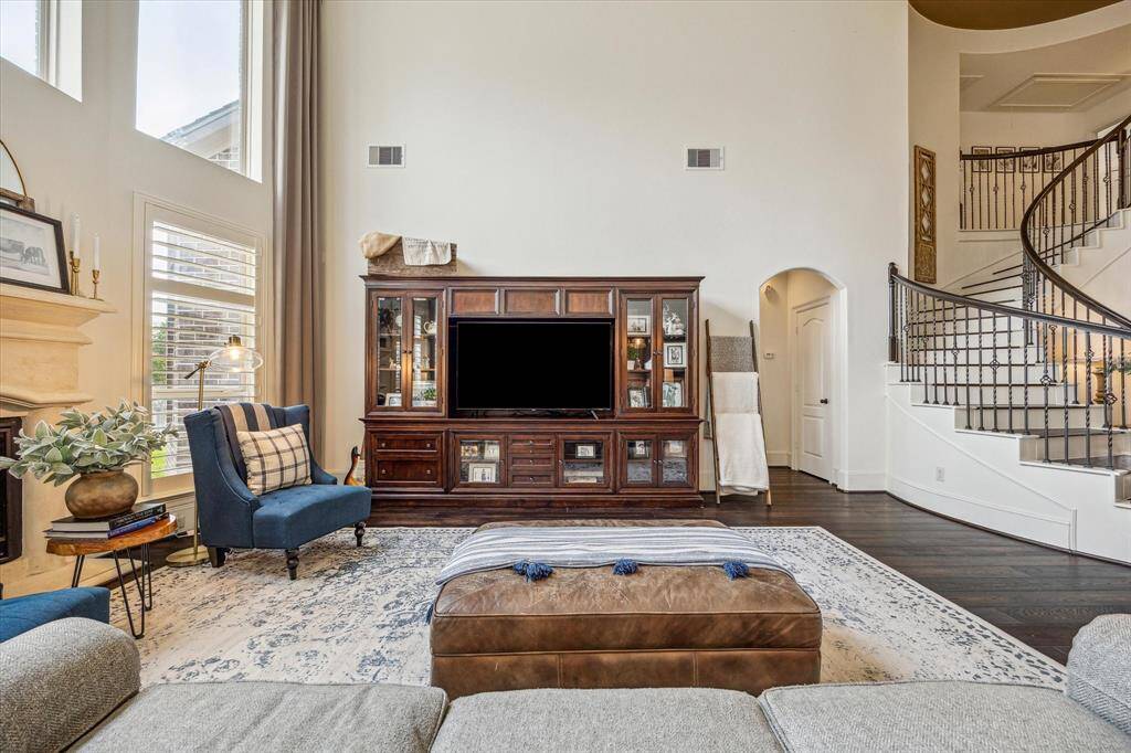 The family room offers ample space for large, cushy furnishings, inviting everyone to gather and unwind in comfort. A soaring ceiling and stacked windows amplify the open, airy ambiance, flooding the room with natural light and creating a stunning sense of grandeur.