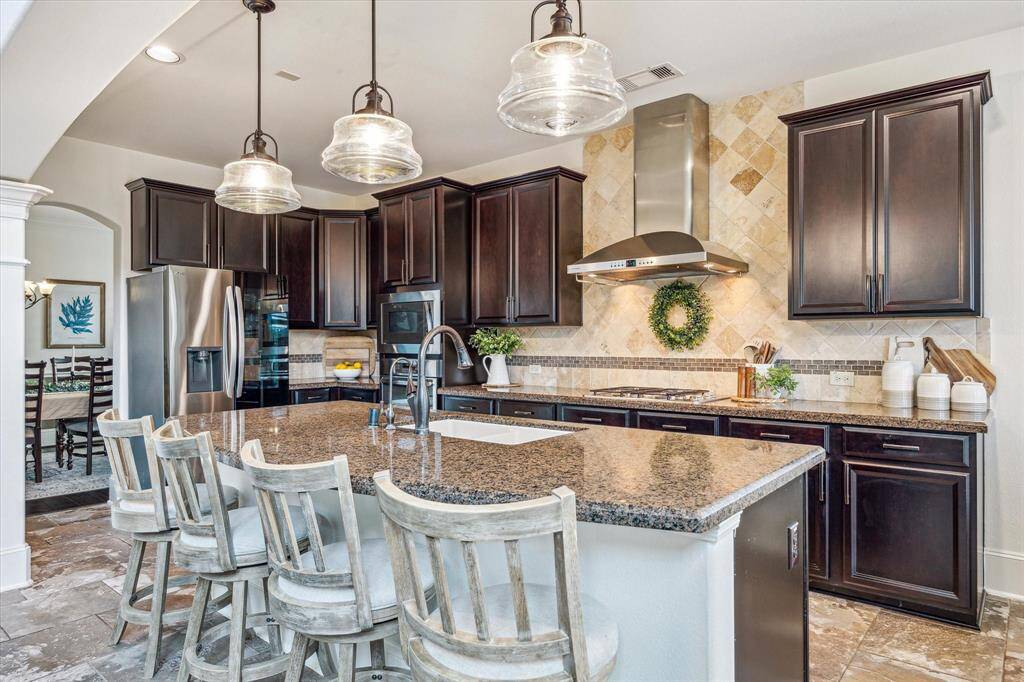 An oversized island separates the kitchen from the family room, offering the perfect spot to serve drinks and snacks, enjoy a quick meal, or chat with the chef. Add bar stools to transform it into a welcoming hub for casual gatherings and everyday living.