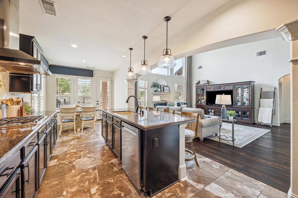 Open to the family room and casual dining area, this kitchen offers a modern layout designed for easy everyday living and seamless entertaining. It’s beautifully appointed with granite countertops, stylish tile backsplash, sleek stainless steel appliances, and a spacious walk-in pantry for added convenience.