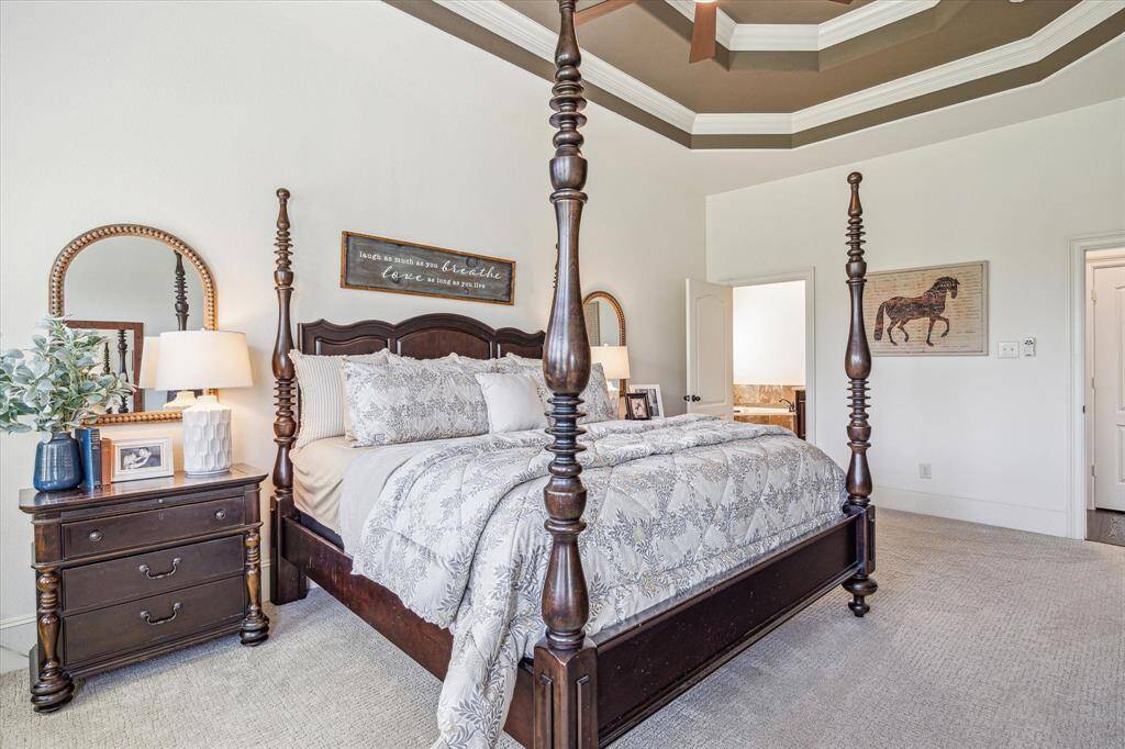 What a wonderful space to begin and end your day. This luxurious retreat offers plenty of room for a California king and more, with a charming sitting area nestled by wood-shuttered bay windows, perfect for relaxing in comfort and style.