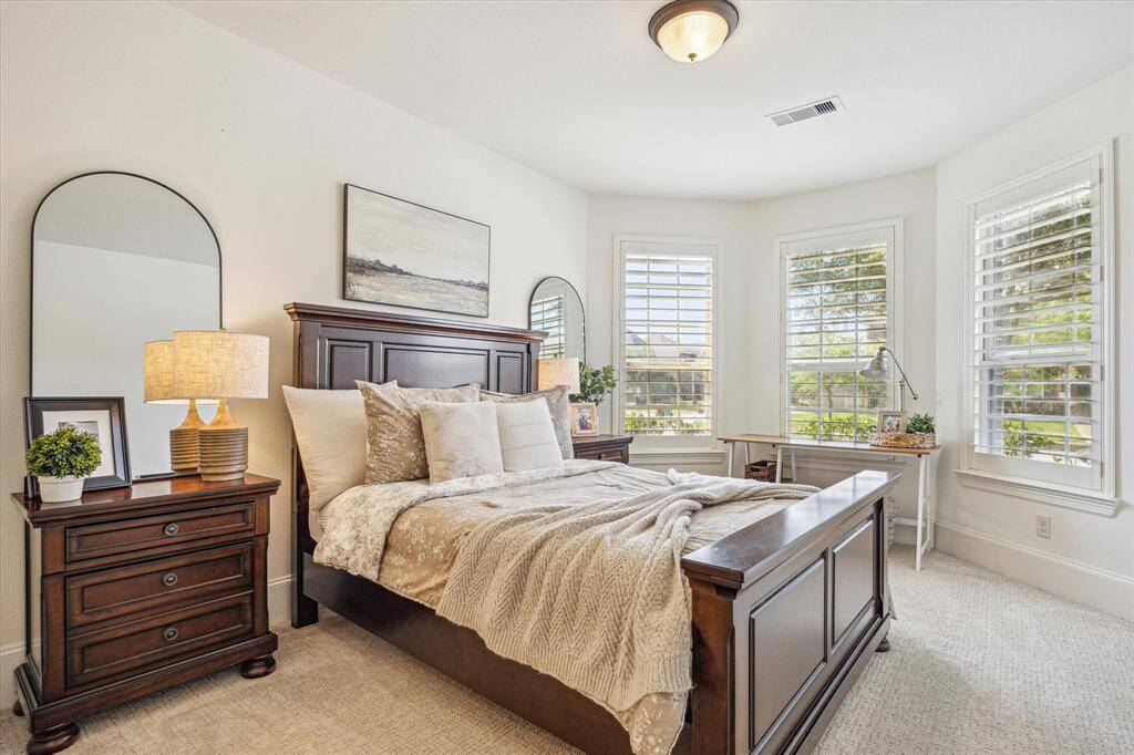 Perfect for long term guests, this first-floor suite offers an inviting space for family and friends. It features soft neutral carpet and paint, a wall of bay windows with wood shutters, a large closet and ensuite access to a full bathroom.