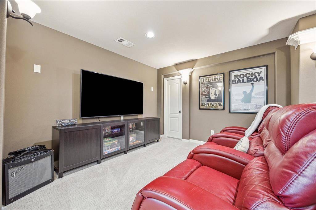 The media room is ready for action, featuring plush carpet, designer paint, and stylish sconce lighting that sets the perfect movie-night mood. With a convenient snack bar setup and ample space for theater-style seating, it’s an entertainer’s dream.