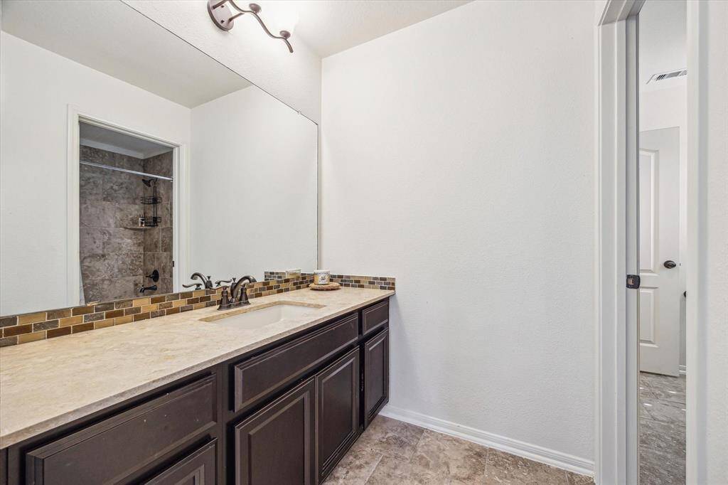 Serving the two upstairs guest suites, this thoughtfully designed full bathroom features private dressing areas, each with a single sink vanity, and a shared water closet. It’s the perfect combination of privacy and functionality for family or overnight guests.