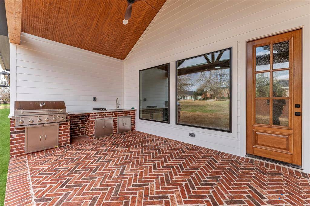 The outdoor living area is equally impressive, with an oversized BBQ grill and a fully equipped outdoor kitchen