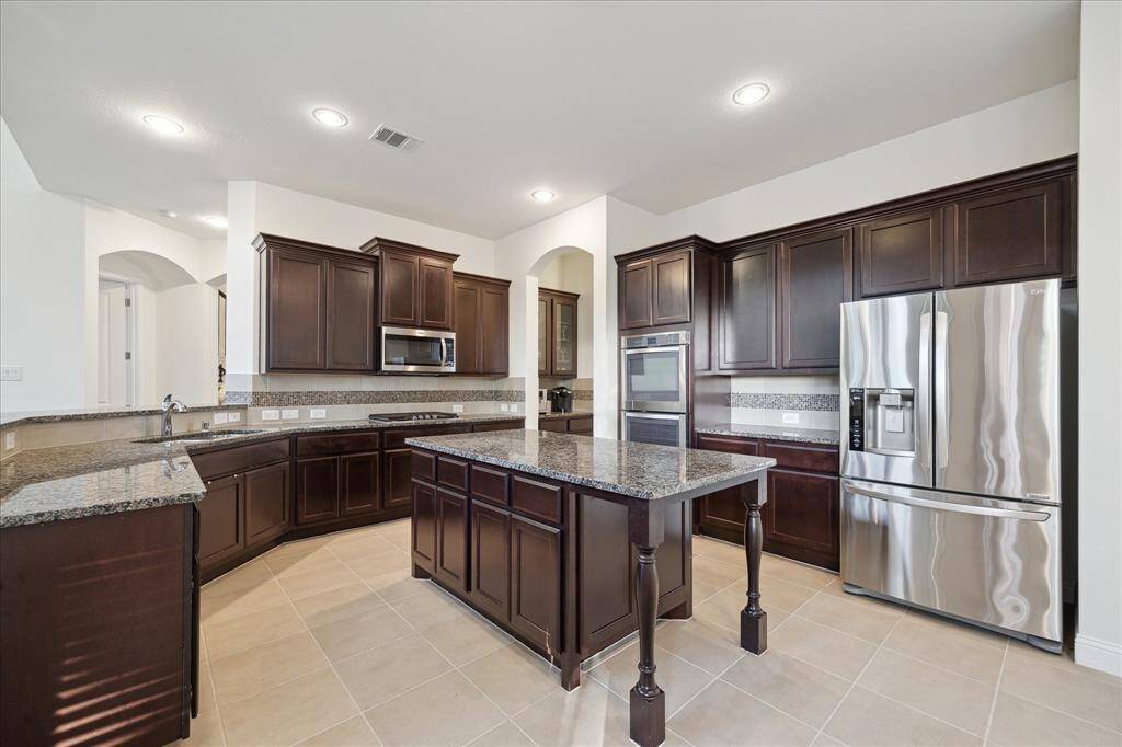 The Chef's Kitchen Has Everything You Need w/ TONS of Cabinet Space, Gas Range, Double Ovens and Plentiful Granite Counters for Prepping and Serving