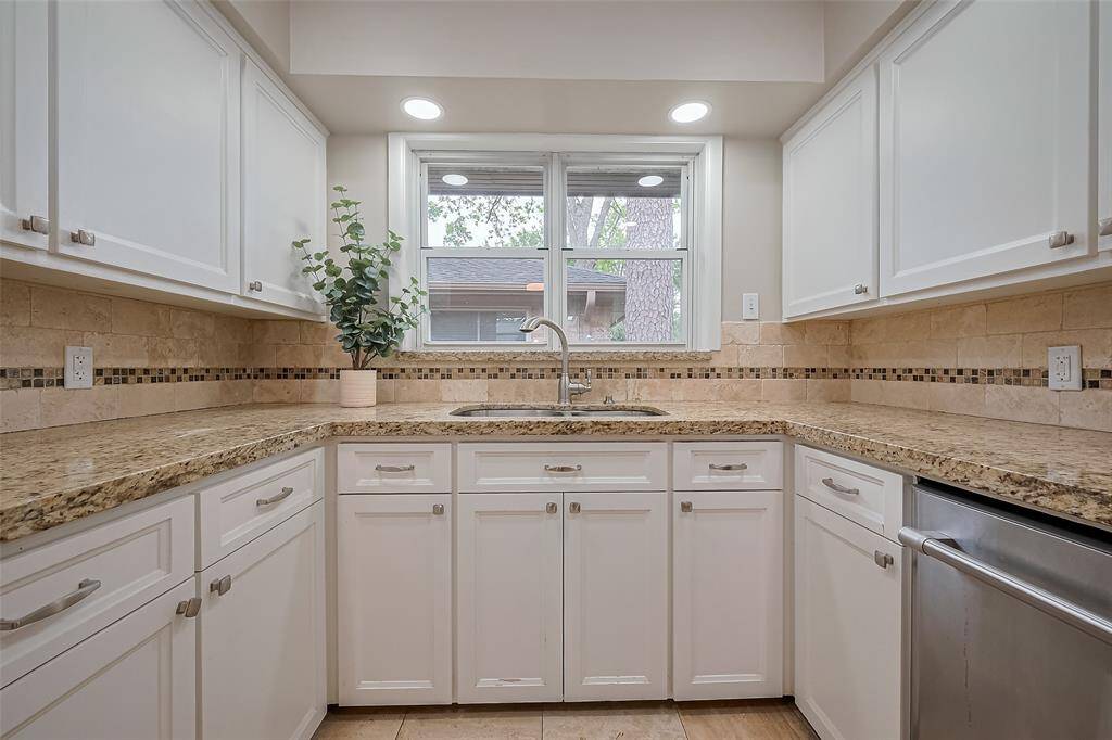 Lovely neutral kitchen with window gracing the stainless sink.