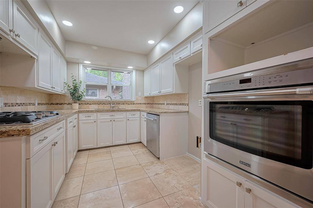 This kitchen features updated led slim lighting a stainless Maytag dishwasher and electric stove.