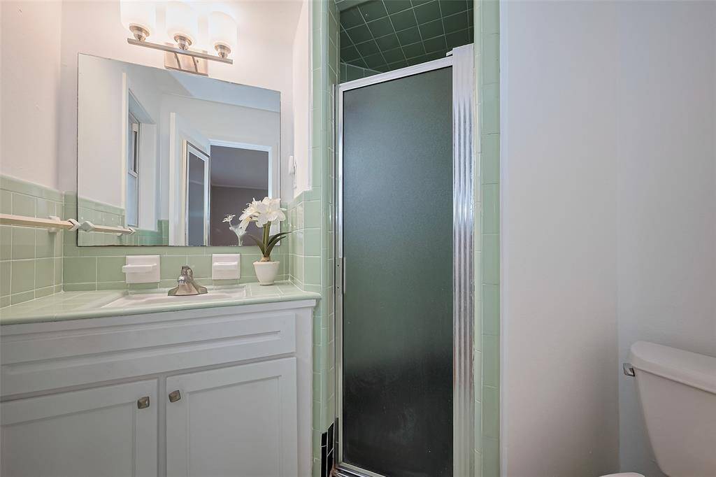 Primary bath is for the vintage lovers with the original well maintained tile and stand up shower.