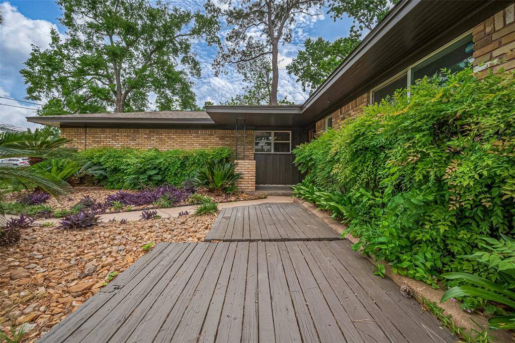 Check out this front deck and the greenery! Perfect place for a bistro table or two comfy outdoor chairs for coffee and conversation.