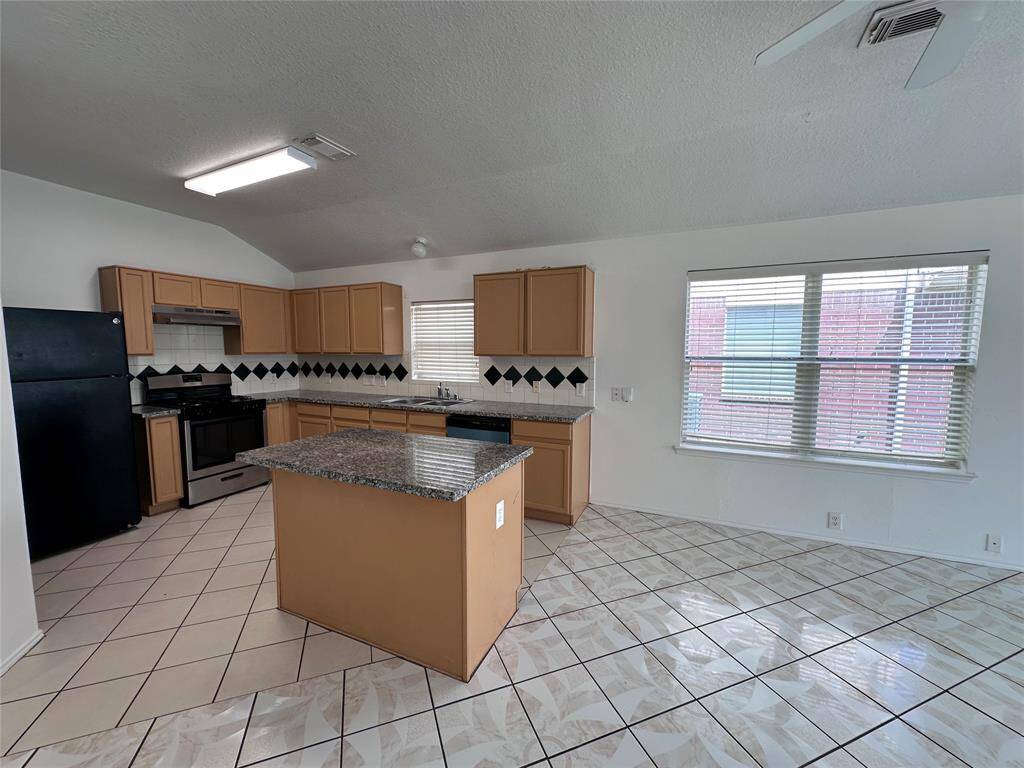 Granite Island Style Kitchen with Tile Flooring