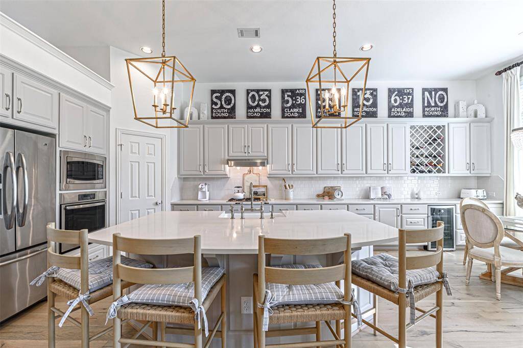 Front view of the gourmet kitchen showing curved kitchen island, wine storage and separate wine fridge