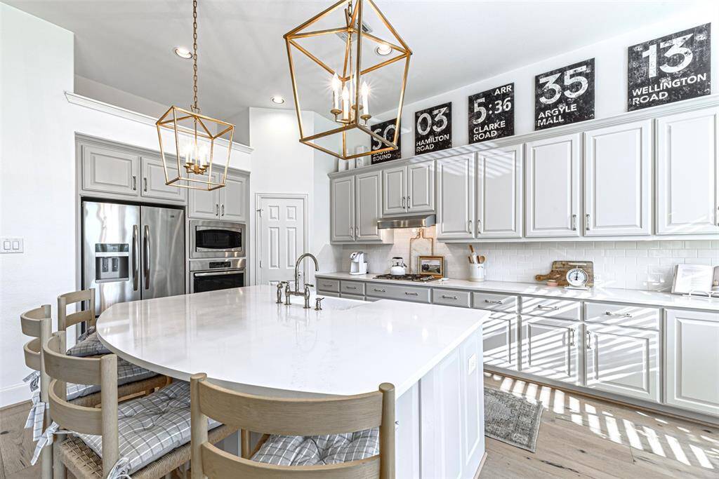 Professionally painted cabinetry and quartz counter top with gooseneck faucet