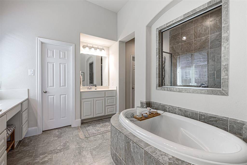 Wide view of the primary bathroom suite with neutral tilework