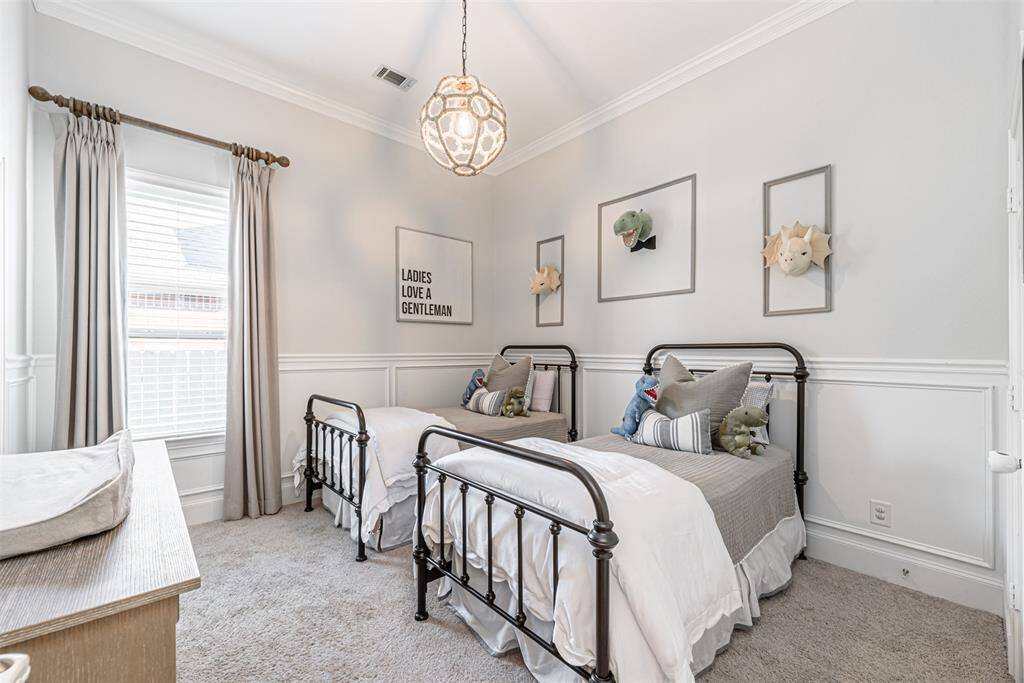 Second bedroom of four with custom woodwork, carpeting and upgraded lighting fixtures