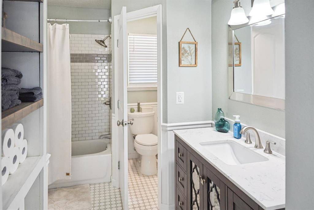 Bathroom – Classic design with a tub/shower combo, modern vanity, and built-in storage.