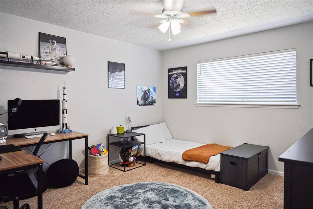 Third Bedroom – Spacious and well-lit with a ceiling fan and large window for natural light.