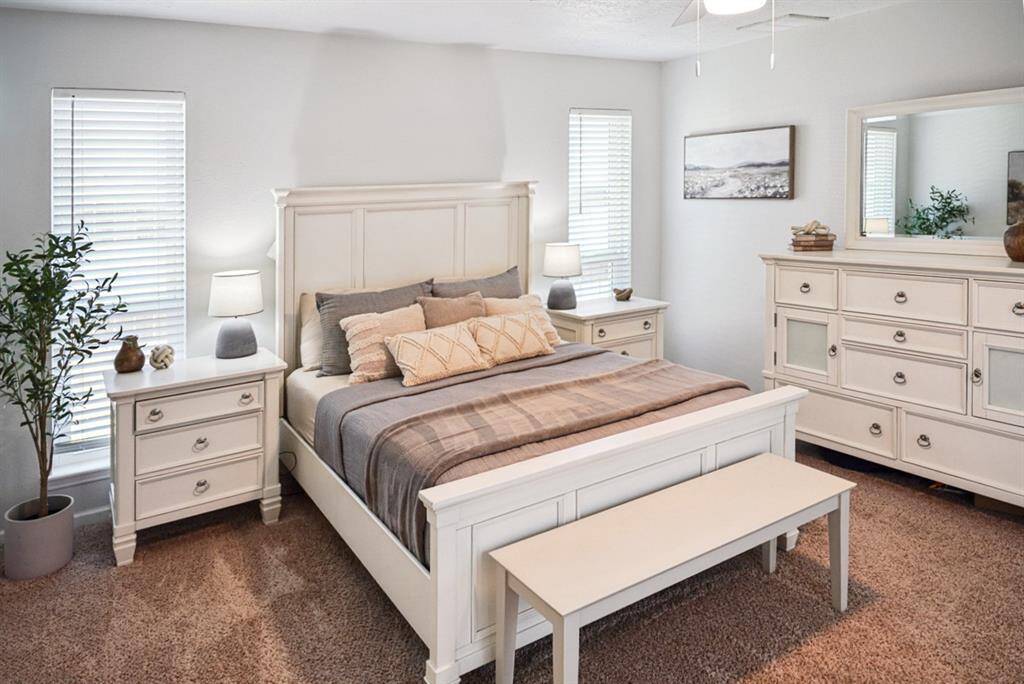 Another Angle of Primary Bedroom – Well-lit space with large windows and stylish furnishings.