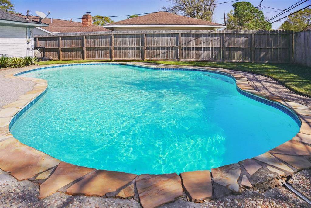 Another Pool View – Large pool with a natural stone border and privacy fencing.