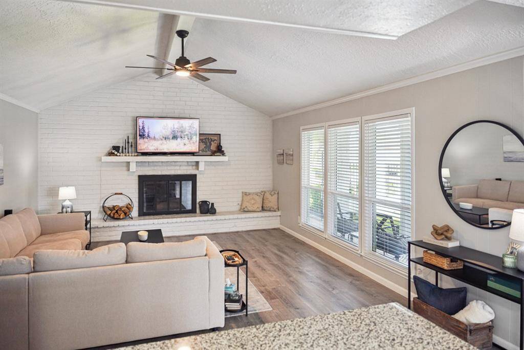 Living Room – Open-concept space with vaulted ceilings, modern flooring, and a cozy fireplace.