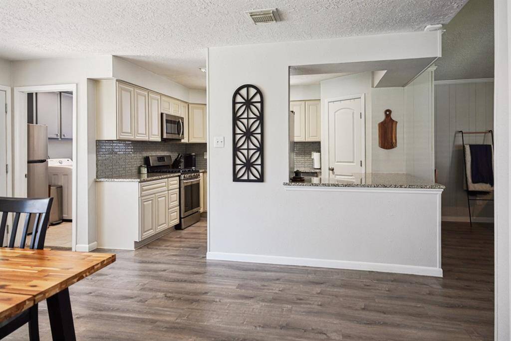 Living Room Alternate View – Spacious and bright, with neutral tones and a brick fireplace.