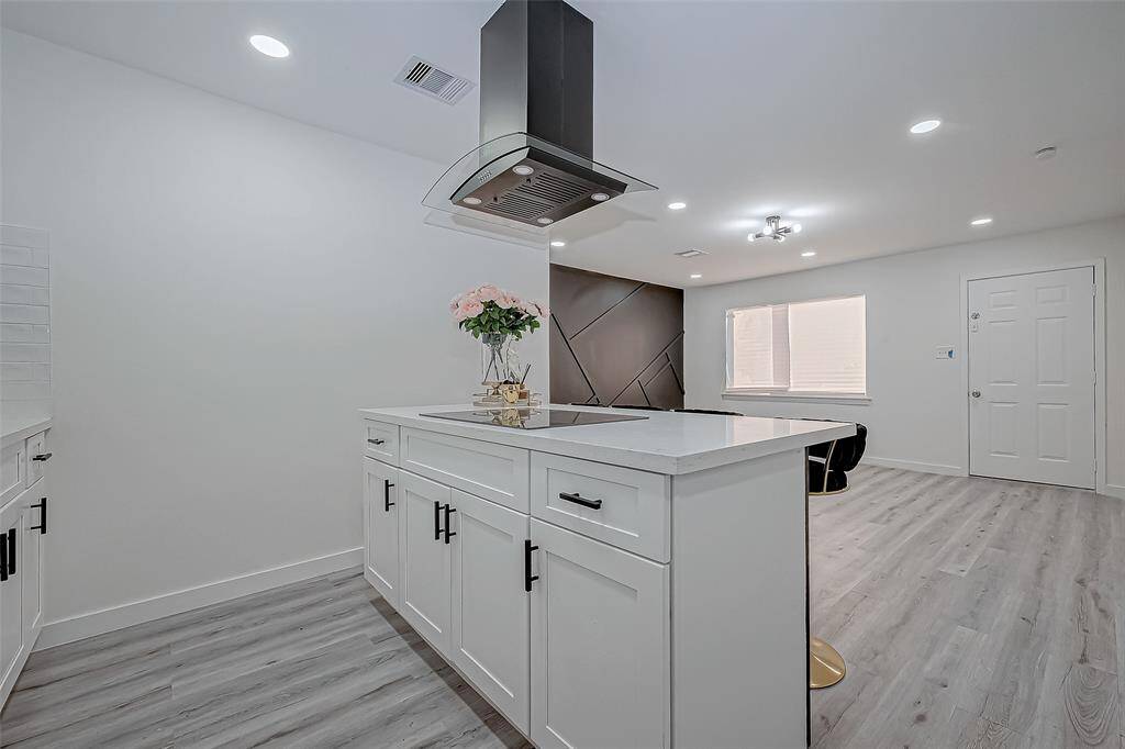 A spacious kitchen island provides additional workspace and doubles as a casual dining area, making it a versatile centerpiece for the room.