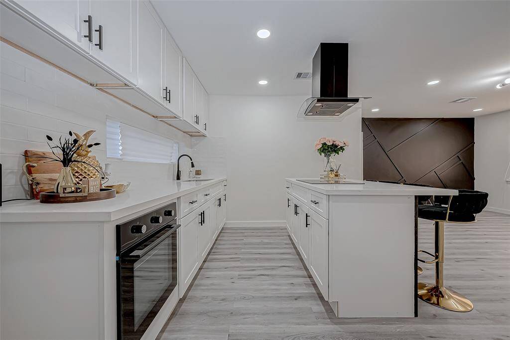 The open-concept design connects the kitchen seamlessly to the living room, creating a welcoming and airy space where cooking, dining, and relaxing flow together effortlessly.