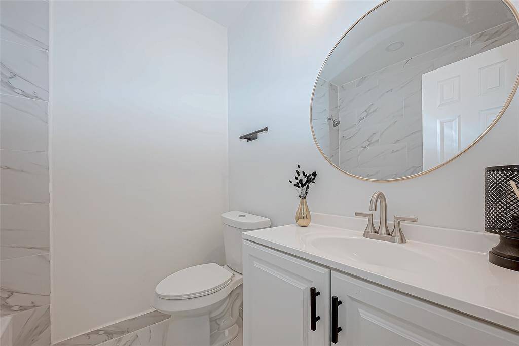 The primary bathroom features elegant porcelain finishes that add a touch of luxury and sophistication, creating a spa-like atmosphere.