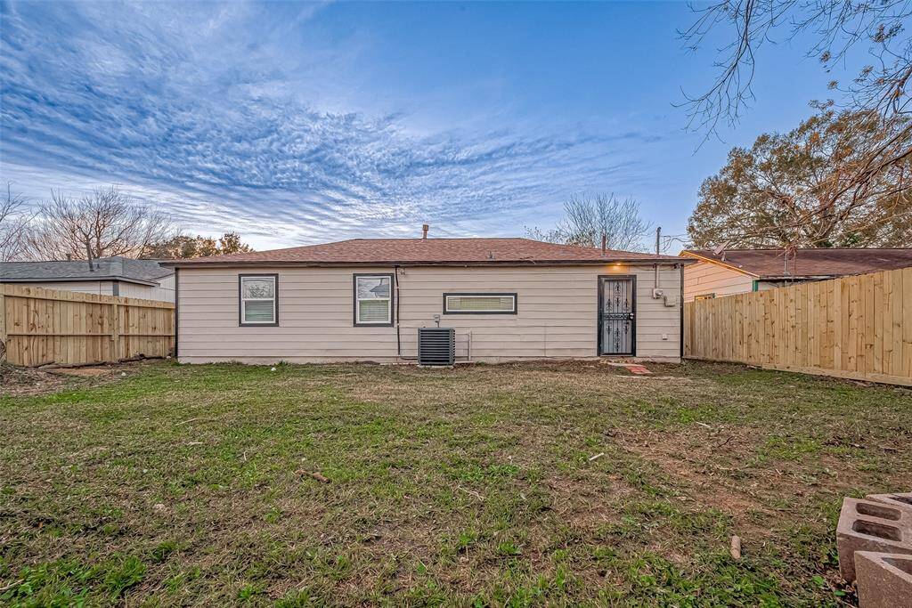 A large, mature tree provides natural shade, creating a peaceful retreat ideal for enjoying warm Houston afternoons or hosting outdoor gatherings.