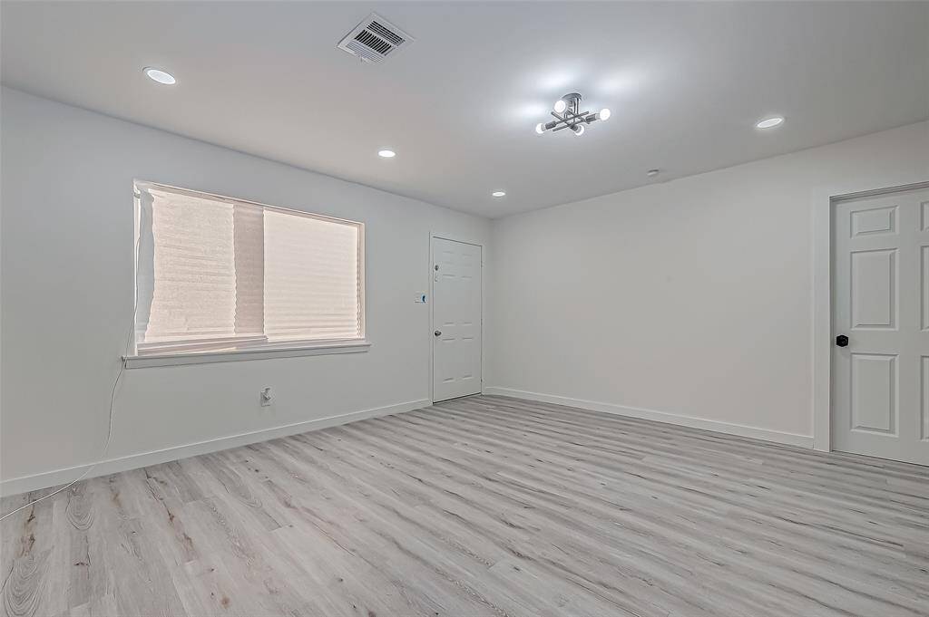 Large windows fill the living room with natural light, creating a bright and airy atmosphere during the day while providing a view of the surrounding outdoor space.
