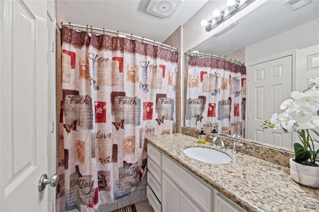 Primary bathroom with granite countertop.